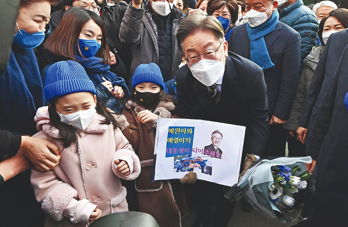 SEJONG, South Korea: Picture shows South Korean presidential candidate Lee Jae-myung (C) of the ruling Democratic Party posing with supporters during an election campaign at a market in Sejong. – AFP