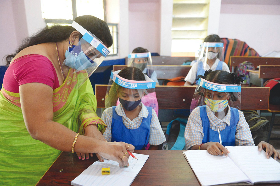 HYDERABAD: Students wearing facemasks and face shields attend a class at a government girls' primary school on Friday. - AFP