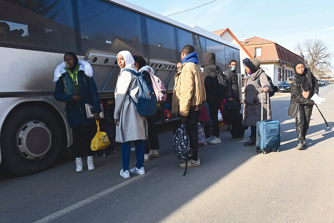 TARPA, Hungary: University students, including many from Nigeria, fleeing from the Ukrainian capital Kyiv, stow their luggage as they get on their transport bus close to the Hungarian-Ukrainian border in the village of Tarpa in Hungary yesterday. - AFP
