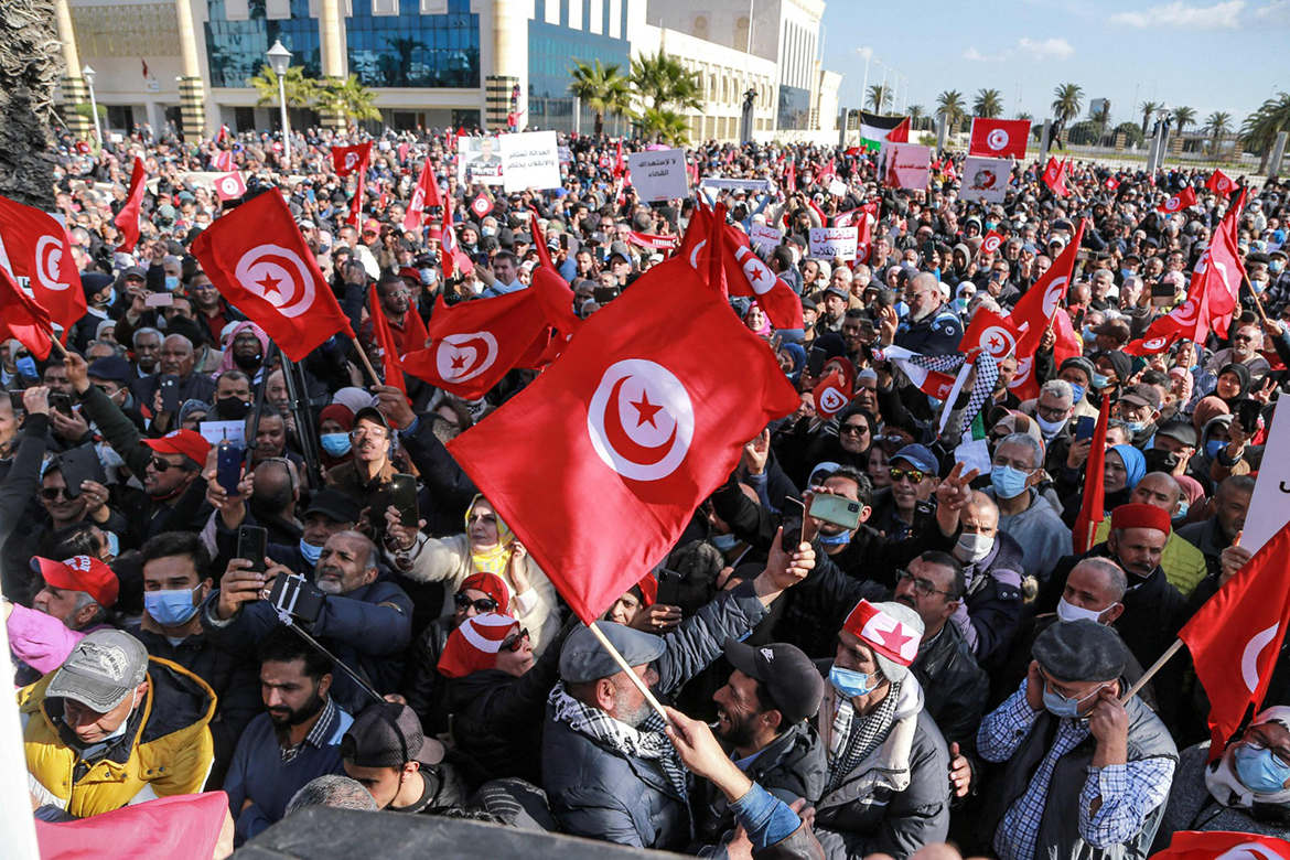 TUNIS: Protesters wave national flags during a demonstration against President Kais Saied's recent decrees outside the Tunis Opera House yesterday. - AFP