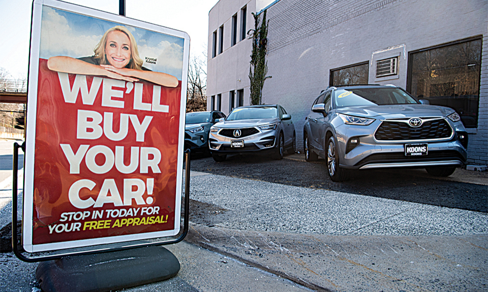 ARLINGTON, US: A sign advertises to purchase cars at a used car dealership in Arlington, Virginia.—AFP