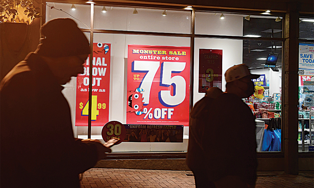 LOS ANGELES: In this file photo taken on January 28, 2022, sales signs are seen in the windows as people shop for bargains at a retail outlet in Los Angeles. US retailers more than regained ground lost in an unexpected December slump, with a surprise boom in January sales, according to government data released yesterday. —AFP