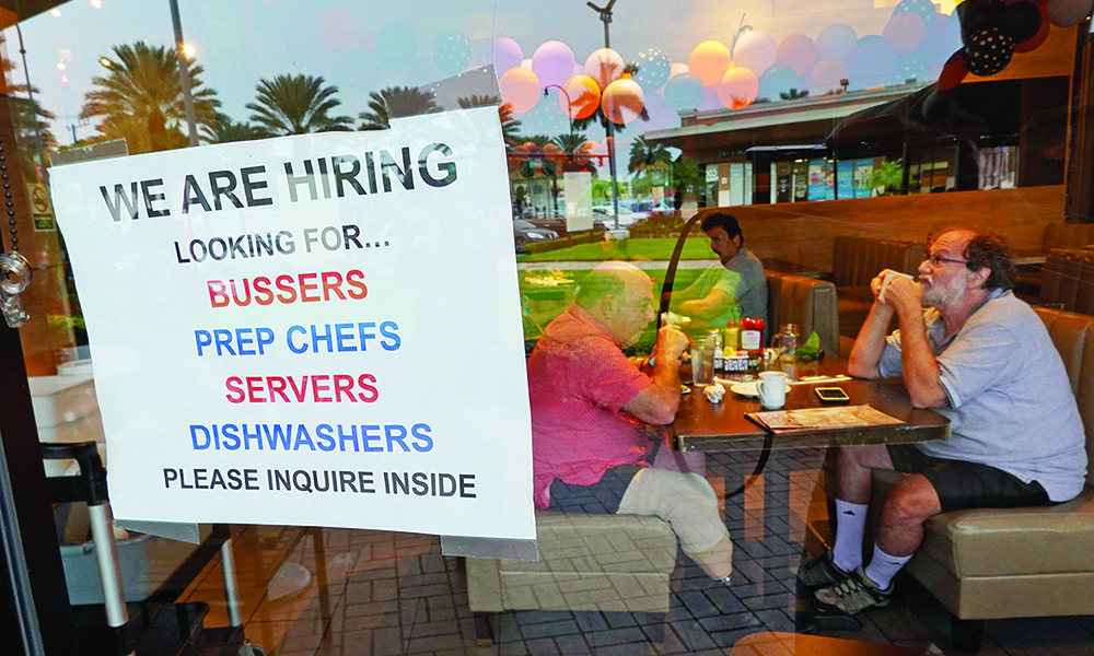 HALLANDALE BEACH,†US: In this file photo, a ‘We Are Hiring” sign hangs near the entrance to Mo’s Bagels &amp; Deli in Hallandale Beach, Florida. — AFP