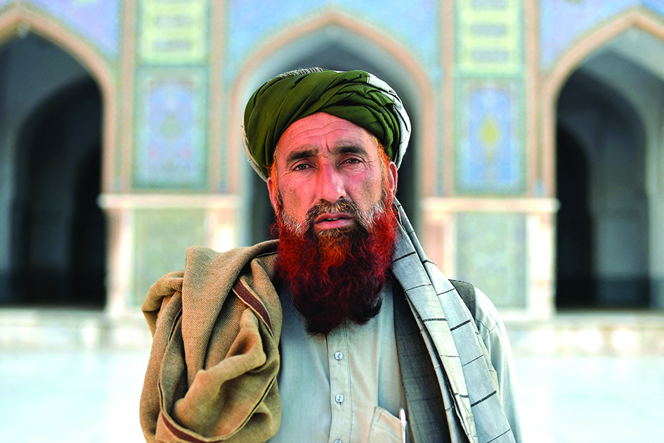 An Afghan man wearing a turban poses for a photograph in the courtyard of Jami Mosque in Herat.<br>