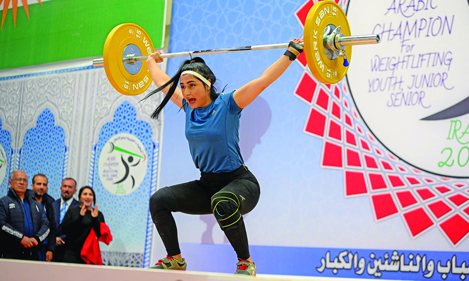 An Iraqi Kurdish woman competes during a weight lifting championship. - AFP photosn