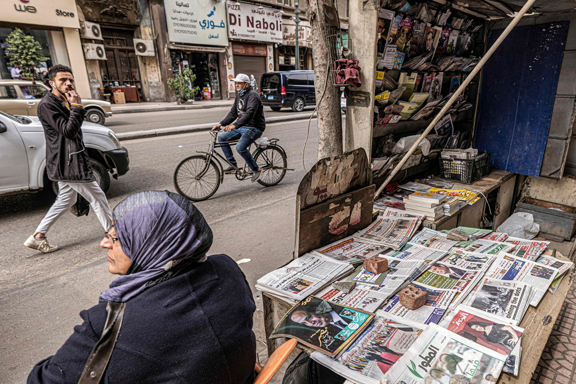CAIRO: A woman sits in a chair next to newspapers on display at a newsstand along Kasr Al-Aini street in the centre of Egypt's capital Cairo. Newspaper sellers were once a dime a dozen on Cairo's bustling streets, but now the vendors hawking hot-off-the-press editions have fallen almost silent. - AFP