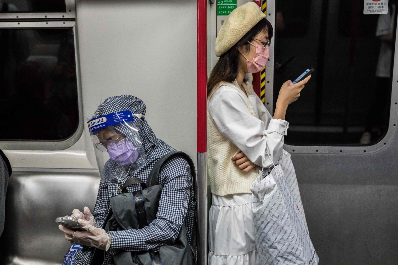 HONG KONG: People wearing face masks as a preventive measure against the COVID-19 coronavirus commute on a train in Hong Kong on March 2, 2022. - AFP