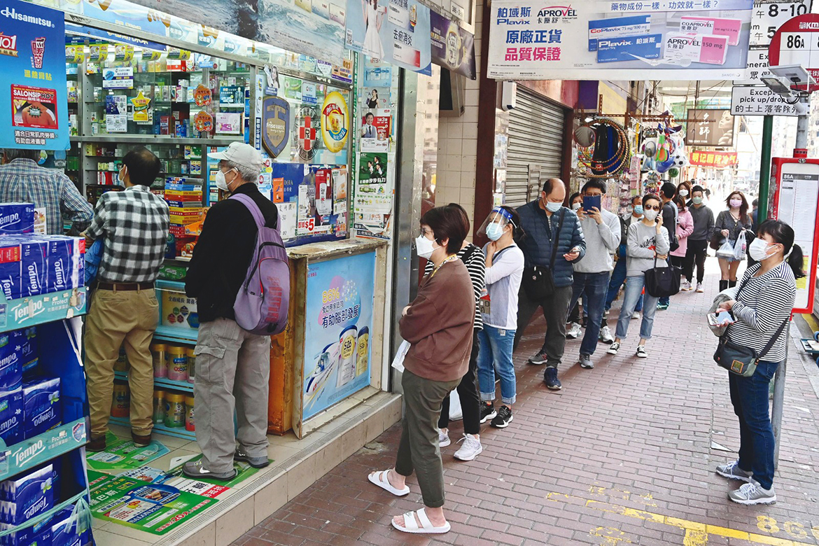 HONG KONG: People queue outside a pharmacy in Hong Kong yesterday, as panic buying returned to the city with many supermarket shelves stripped bare following mixed messaging from the government over whether it plans a city lockdown later this month when it tests all residents. - AFP