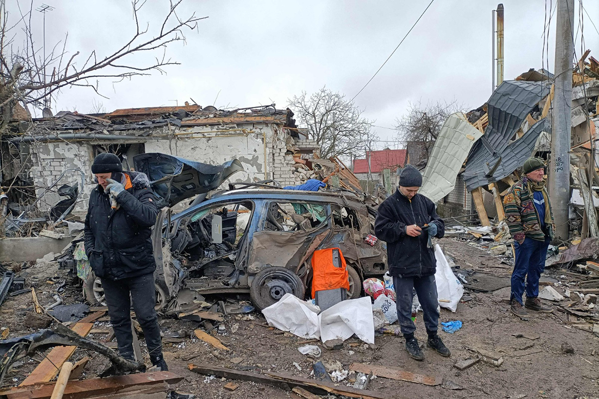 ZHYTOMYR: Three men stand in the rubble in Zhytomyr , following a Russian bombing the day before.- AFP