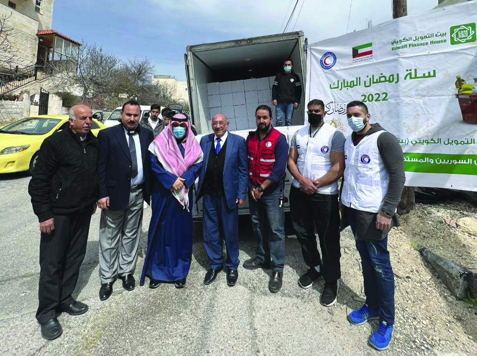 Kuwaiti Ambassador to Jordan Aziz Al-Daihani and other officials pose for a group photo during aid distribution in Balqaa province. - KUNA photos