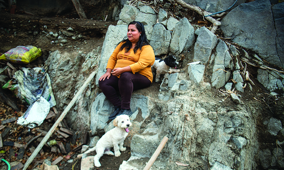 LIMA: Daysi Falcon Lopez, 34, sits next to her dog at her home of the Independencia district, on the eastern outskirts of Lima, Peru on February 26, 2022. -- AFPn