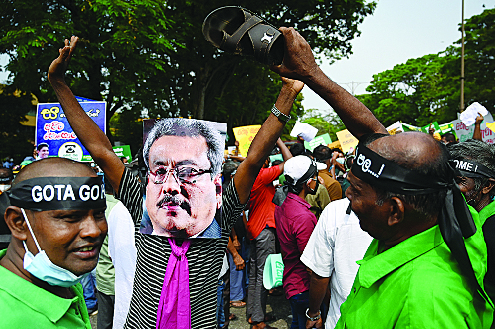 COLOMBO: An opposition activist wears a mask depicting Sri Lanka's President Gotabaya Rajapaksa as he protests along with others against rising living costs, at the entrance of the president's office in Colombo. - AFPnn