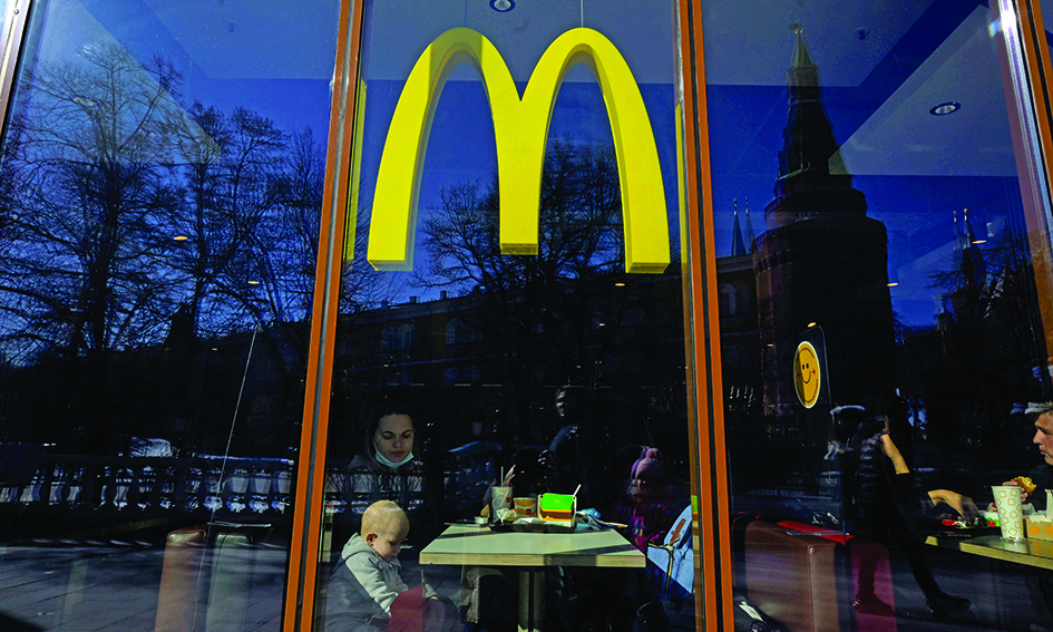 People have lunch at a McDonald's fast food restaurant in central Moscow on March 9, 2022. - McDonald's, Coca-Cola and Starbucks on March 8, 2022 bowed to public pressure and suspended their operations in Russia, joining the international corporate chorus of outrage over Moscow's invasion of Ukraine. Several of these companies, symbols of American cultural influence in the world, have been the subject of boycott calls on social media as investors have also begun to ask questions about their presence. (Photo by - / AFP)