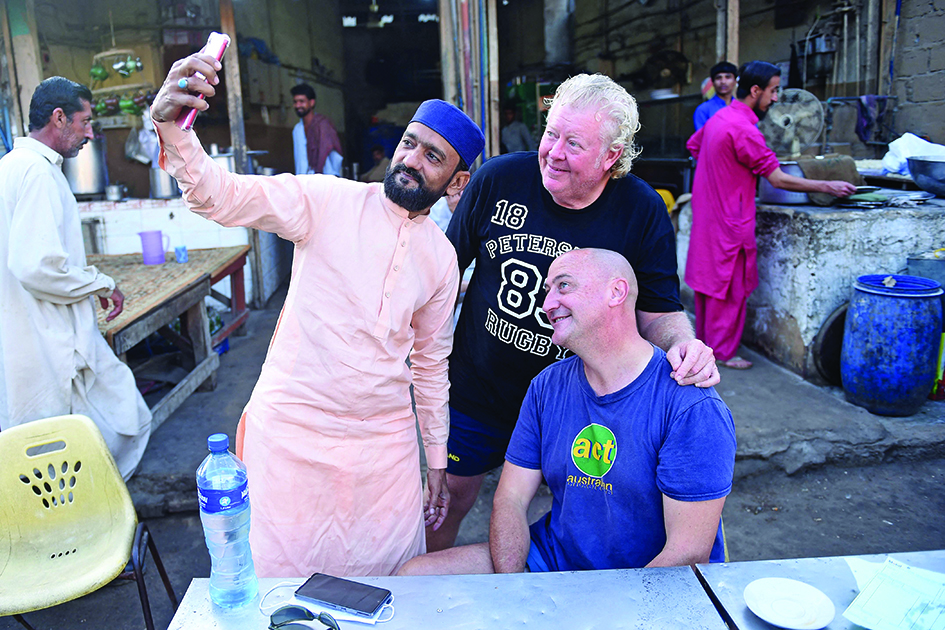 KARACHI: A local resident poses for a selfie with Australian cricket fan Luke Gillian (right) in Karachi. - AFPn