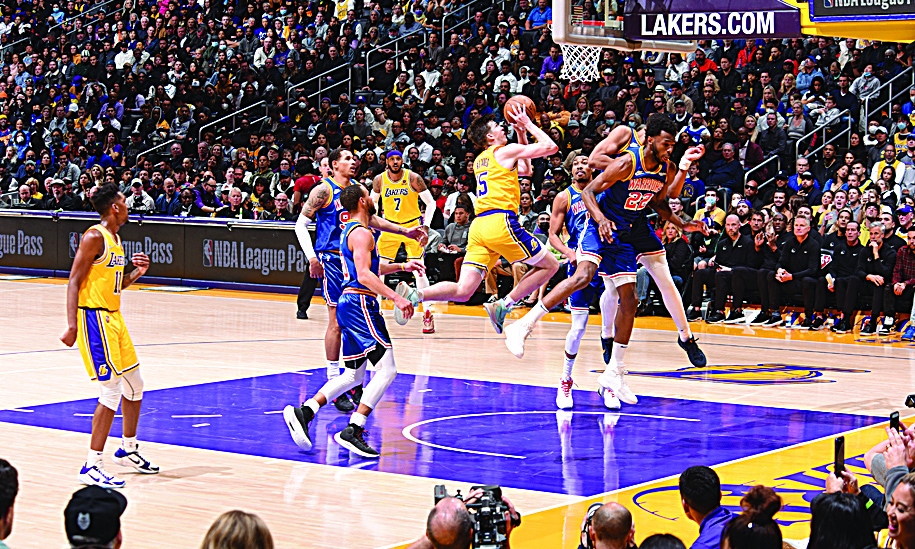 LOS ANGELES: Austin Reaves #15 of the Los Angeles Lakers drives to the basket during the game against the Golden State Warriors on March 5, 2022. - AFPn