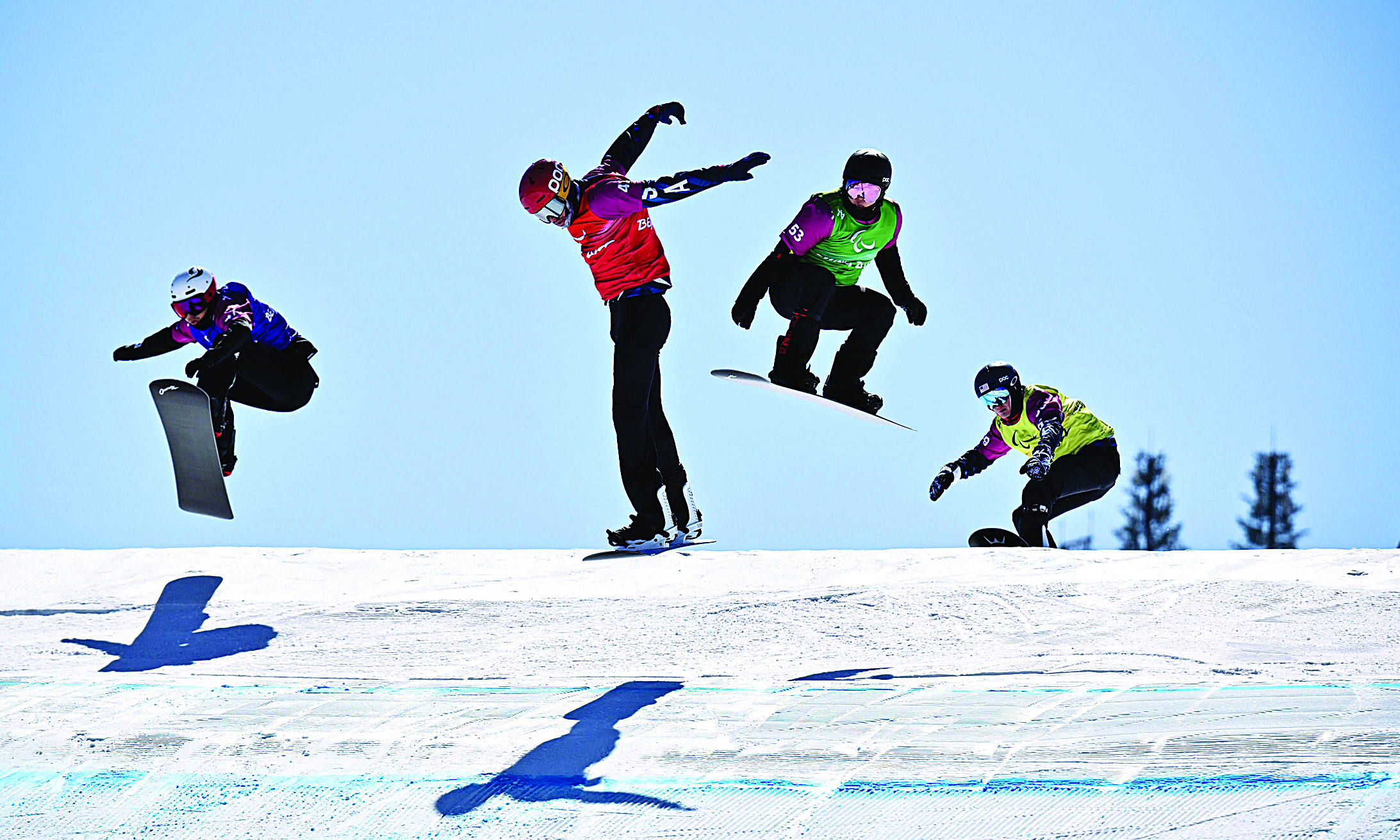 ZHANGJIAKOU: (Left to right) South Korea's Lee Jehyuk, USA's Garrett Geros, China's Sun Qi and USA's Zach Miller compete during the men's snowboard cross SB-LL2 quarter-final event yesterday at the Zhangjiakou Genting Snow Park, during the Beijing 2022 Winter Paralympic Games. - AFPn
