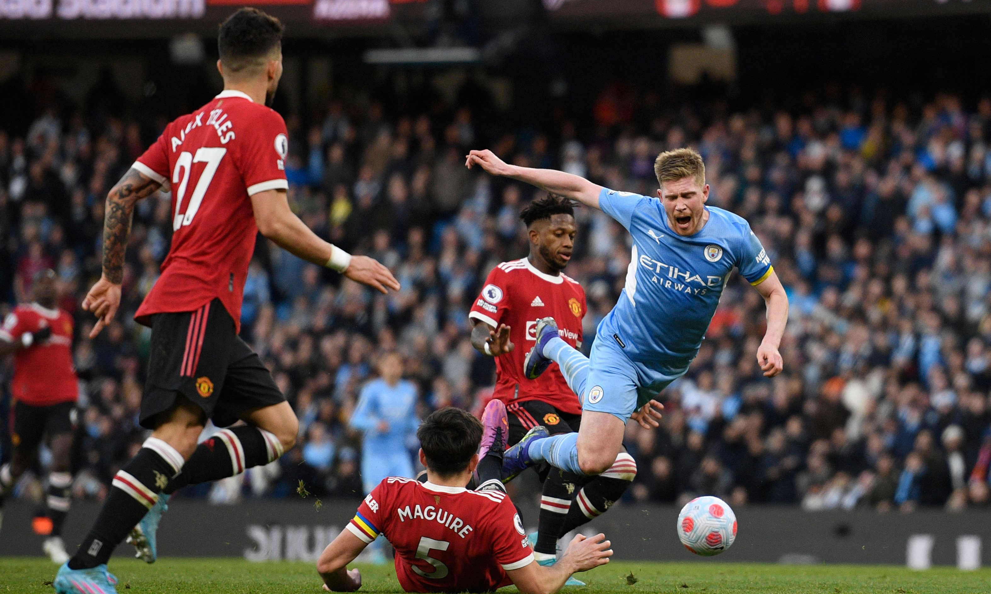 MANCHESTER: Manchester United's English defender Harry Maguire (center) tackles Manchester City's Belgian midfielder Kevin De Bruyne (right) during the English Premier League football match between Manchester City and Manchester United yesterday.- AFPn