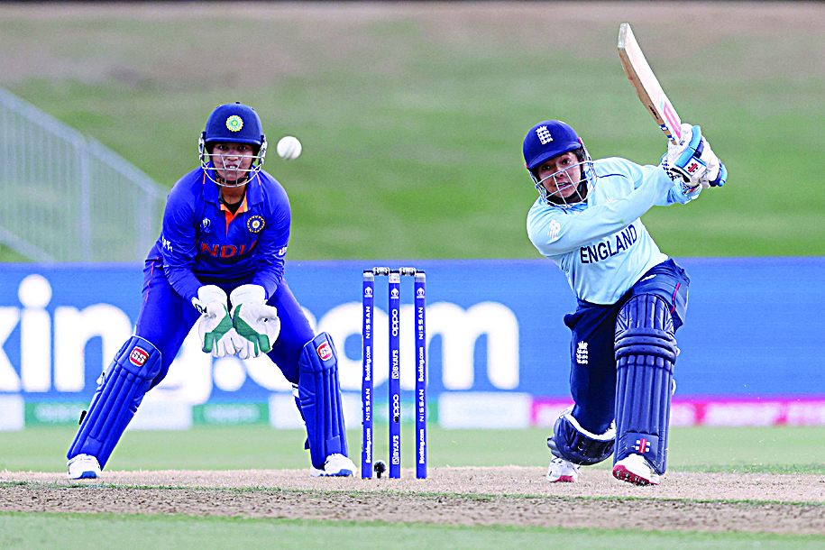TAURANGA: England's Sophia Dunkley (right) plays a shot watched by India's Richa Ghosh during the 2022 Women's Cricket World cup match between England and India at the Bay Oval in Tauranga yesterday.- AFPn