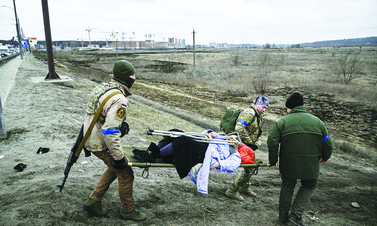 IRPIN, Ukraine: Ukrainian servicemen evacuate an elderly woman on a stretcher yesterday as Russian forces advanced ever closer to the capital from the north, west and northeast. - AFP n