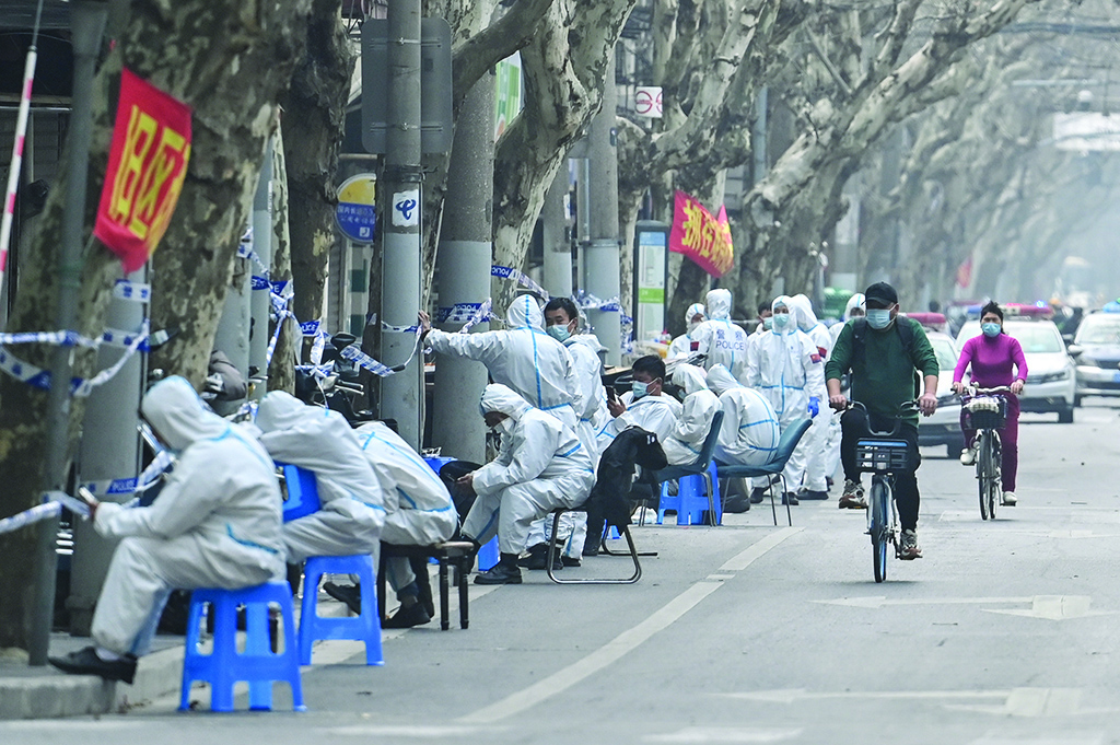SHANGHAI: Workers in protective clothes are seen next to some locked down areas after the detection of new cases of COVID-19 yesterday. - AFP n