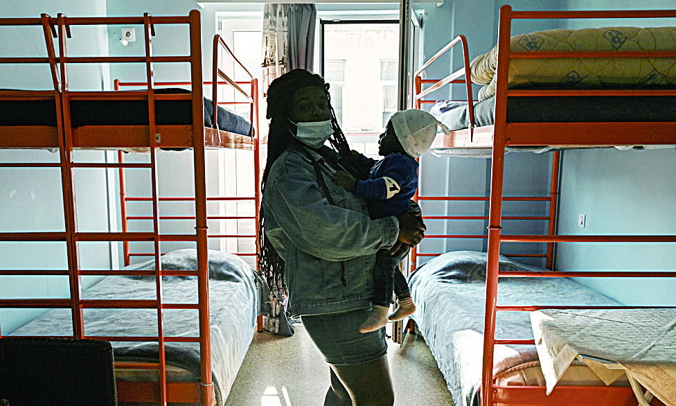 ATHENS, Greece: Ruth, a Congolese asylum-seeker, victim of domestic violence, holds the youngest of her three sons in a shelter for abused refugee women, run by the NGO Doctors of the World (Medecins du monde, MDM), in Athens. - AFPn