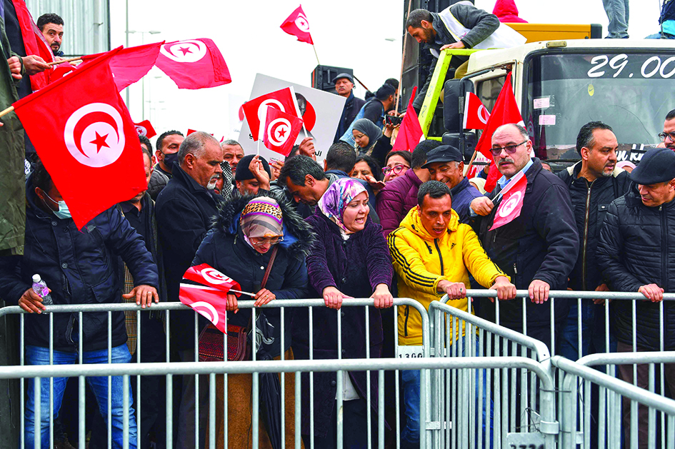 TUNIS: Tunisian protesters try to remove metallic barriers installed by security forces, during a demonstration against their president, not far from the Tunisian Assembly (parliament) headquarters, in the capital Tunis, yesterday. – AFPnnn