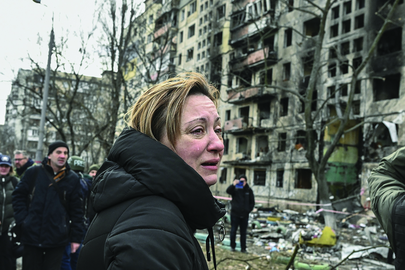KYIV: A woman reacts as she stands outside destroyed apartment blocks following shelling in the northwestern Obolon district of Kyiv yesterday.-AFPnn