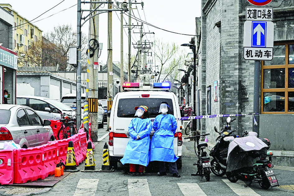 BEIJING: Police in protective gear cordon off an alley after new confirmed cases of COVID-19 were detected in an area of Beijing yesterday. – AFPn