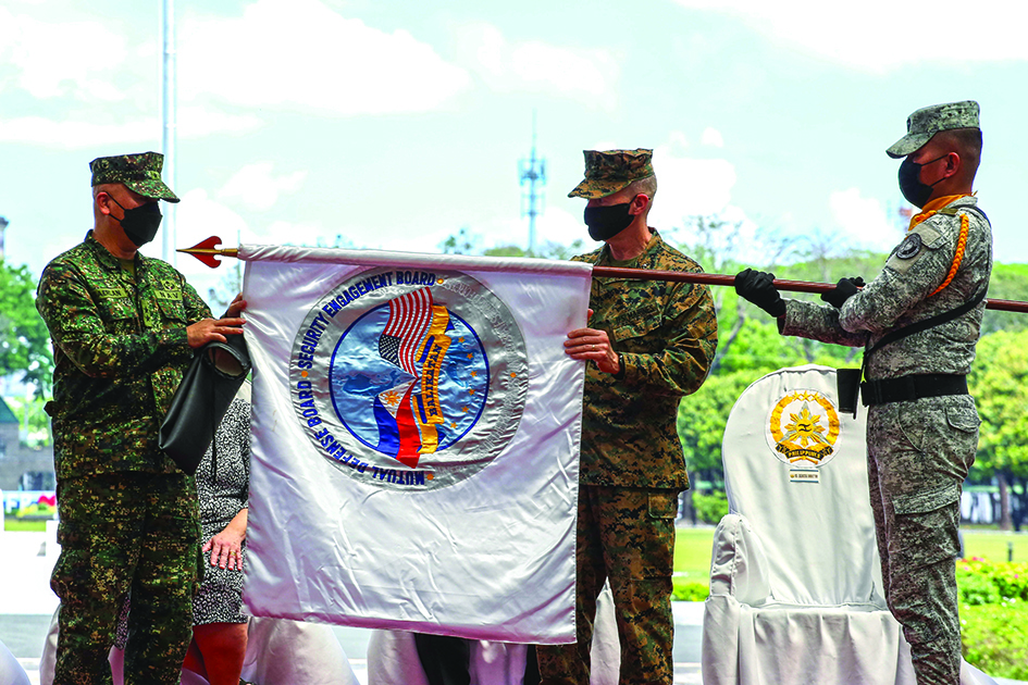 QUEZON CITY, Philippines: Philippine Balikatan Exercise Director Maj. Gen. Charlton Sean Gaerlan (L) and US Exercise Director Maj. Gen. Jay Bargeron (2nd R) unfurl the Balikatan flag during the opening ceremony for a 12-day joint military drill, at Camp Aguinaldo in Quezon City, east of Manila on March 28, 2022. – AFP