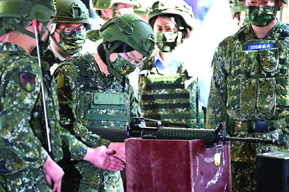 TAOYUAN, Taiwan: Taiwan President Tsai Ing-wen (center) checks a rifle while inspecting reservists training at a military base in Taoyuan on Sunday. -- AFPn