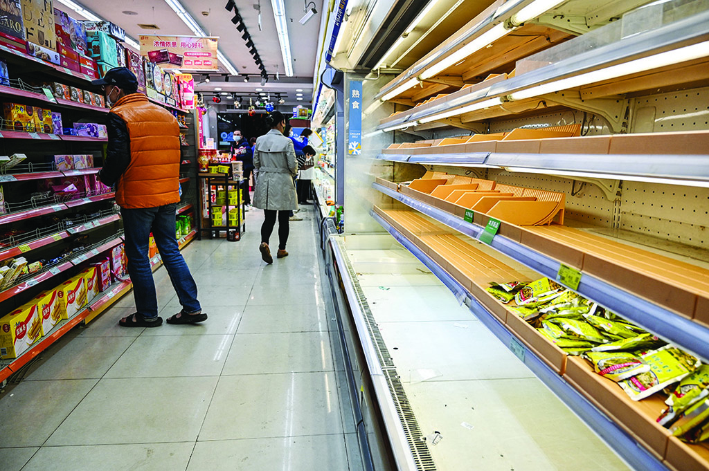 SHANGHAI: Shoppers rummage through empty shelves in a supermarket before a lockdown as a measure against the COVID-19 coronavirus in Shanghai on March 29, 2022. - AFP