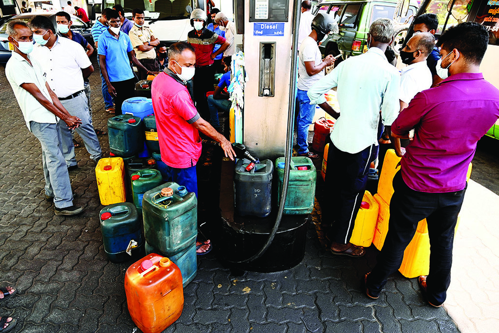 COLOMBO: People stand in a queue to buy diesel at a Ceylon Petroleum Corporation fuel station in Colombo on March 29, 2022.- AFP