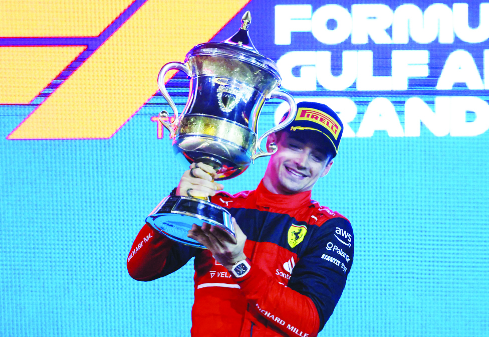 Ferrari's Monegasque driver Charles Leclerc celebrates on the podium winning the Bahrain Formula One Grand Prix at the Bahrain International Circuit in the city of Sakhir on March 20, 2022. (Photo by Giuseppe CACACE / AFP)