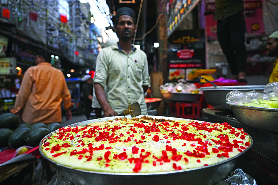 A shopkeeper selling a sweet dish waits for customers at a market on the first day of the holy fasting month of Ramadan in the old quarters of Delhi. —AFP photos