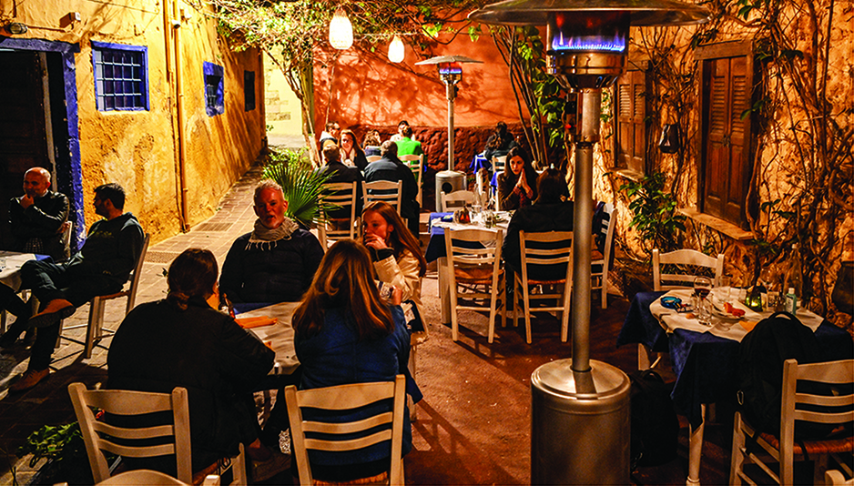 In this file photo tourists sit at a restaurant in the old town of Chania on Crete Island as the tourist season has started on the island. –AFP photos