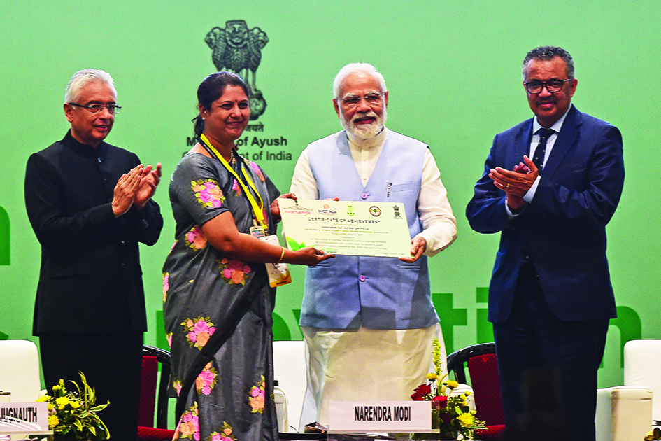 Indian Prime Minister Narendra Modi (second right) present a certificate of achievement next to Director-General of the World Health Organization (WHO) Tedros Adhanom Ghebreyesus (right) embrace during the Global Ayush Investment and Innovation Summit in Gandhinagar yesterday.—AFP  