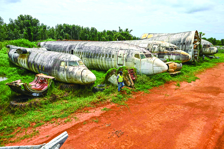 An employee of Aziz Alibhai walks past wreckage of airplanes that are displayed on the edge of a landing strip in Songon Dagbe in the Jacqueville region.—AFP photos