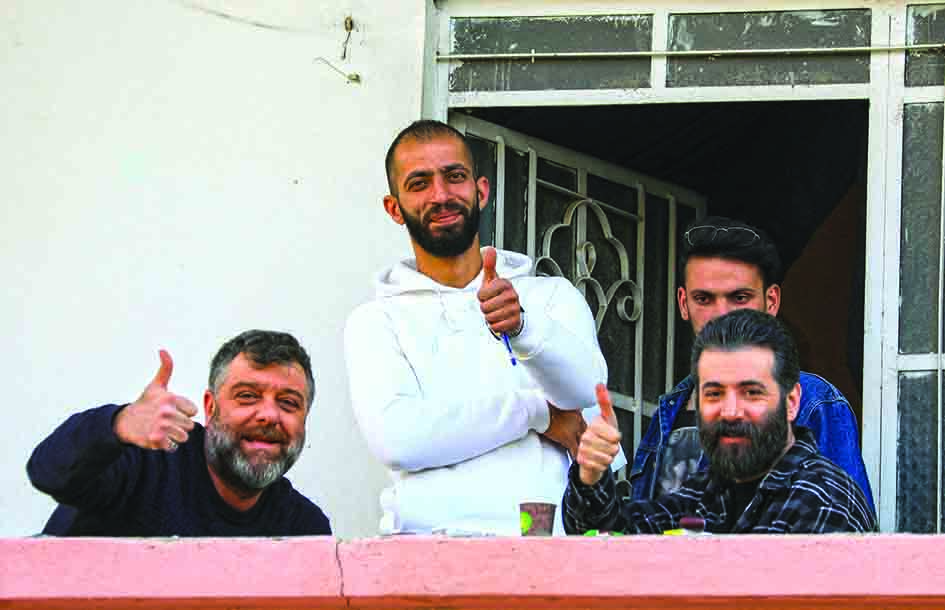Syrian actors Fadi Sobeih (left) and Yamen Al-Hajali (right) gesture thumbs up, during the filming of the Syrian Social series 