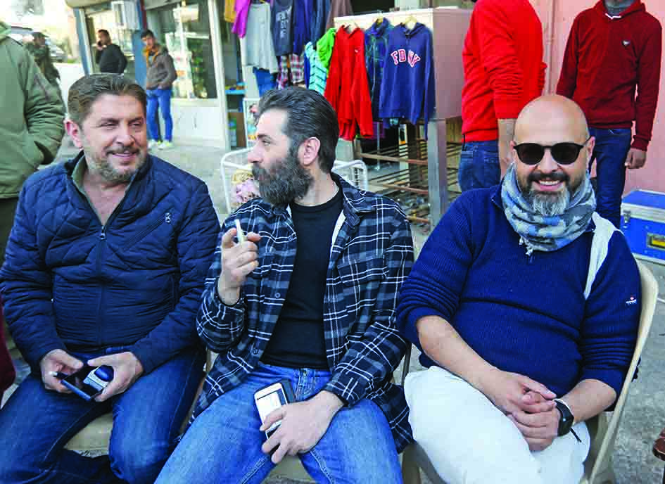 Syrian actors Muhammad Qanu (from left to right) and Yamen Al-Hajali sit with producer Ahmed al-Sheikh, during the filming of the Syrian Social series 