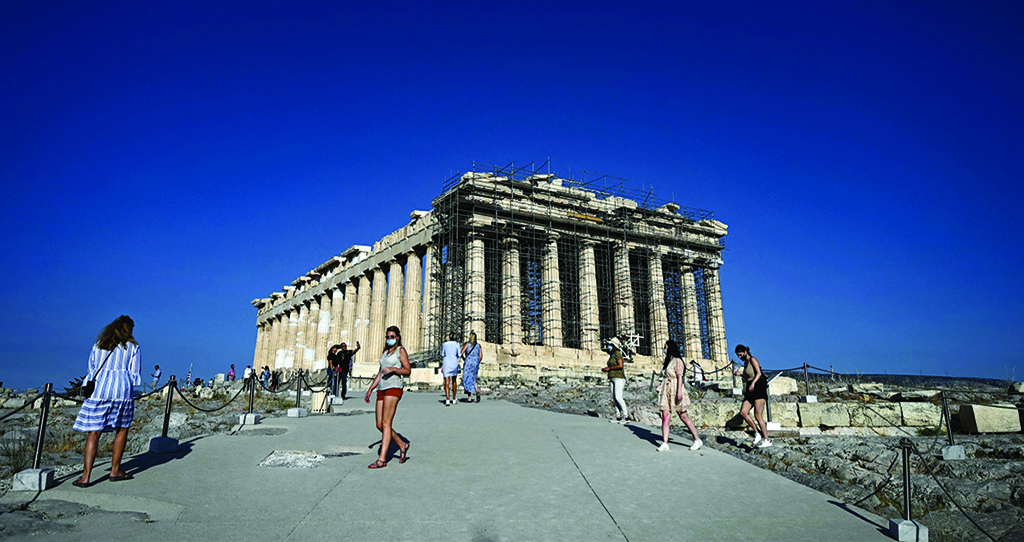 In this file photo tourists walk in front of the Ancient temple of Parthenon on the Acropolis hill in Athens.—AFP photos