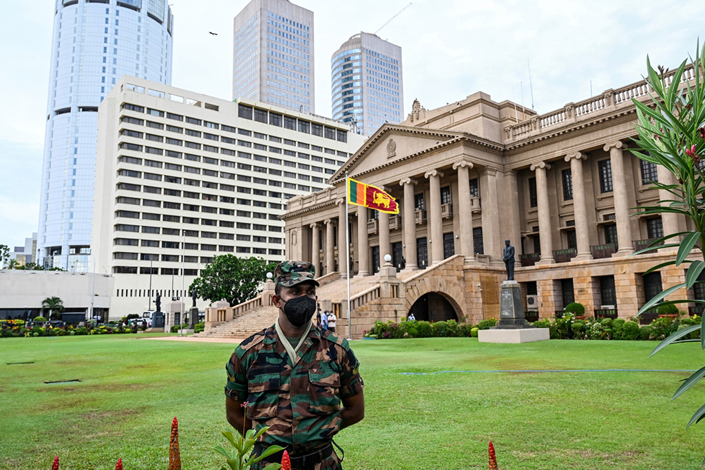 COLOMBO: A soldier stands guard near the entrance of the president's office as protestors take part in a demonstration in Colombo on April 9, 2022. - AFP