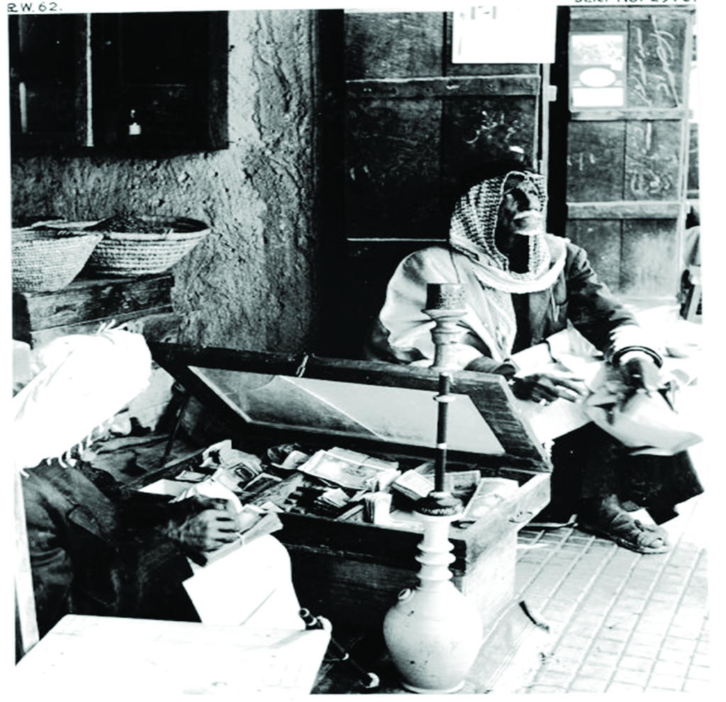 KUWAIT: A scene showing traders in an old market exchanging currencies. One trader is seen sitting next to an open treasury while examining banknotes as a shisha sits besides him. The picture depicts the simple lifestyle of Kuwait in the past. (Source: Photo album of the KOC in 1970s. Prepared by Mahmoud Zakaria Abu Alella, heritage researcher at the Ministry of Information)