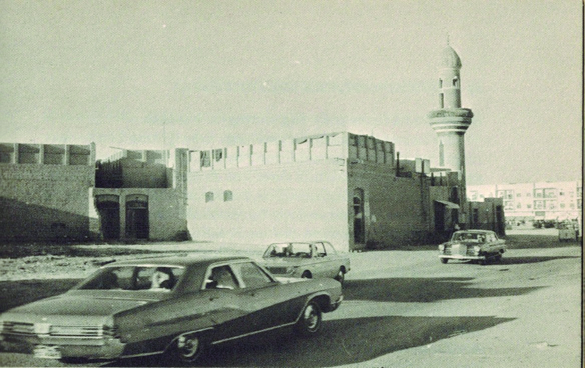 KUWAIT: Imported vehicles drive on a newly paved road in old Kuwait as old buildings are still seen in the background. (Source: 'Kuwait Miracle on the Desert' by David Cooke, New York, 1970. Prepared by: Mahmoud Zakaria Abu Alella, researcher in heritage, Ministry of Information) n