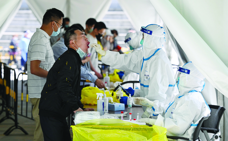 BEIJING: A health worker takes a swab sample from a man to be tested for COVID-19 coronavirus at a makeshift testing site in Zhongguancun in Beijing. - AFP
