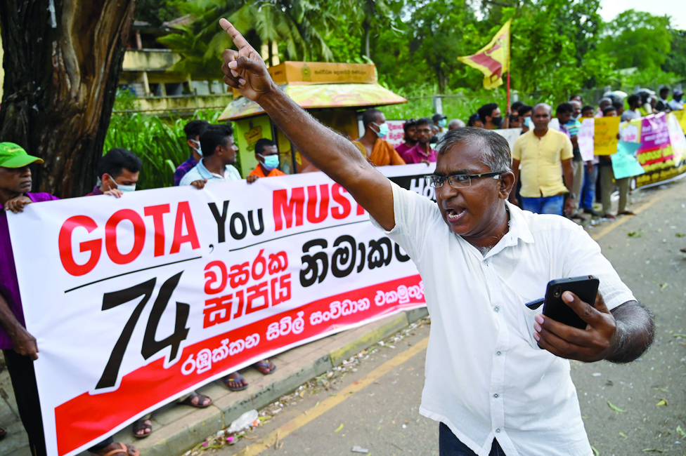 RAMBUKKANA, Sri Lanka: Janatha Vimukthi Peramuna party activists and supporters shout anti-government slogans during a demonstration in Rambukkana on April 20, 2022, a day after police killed an anti-government demonstrator while dispersing a protest against the high fuel prices and to demand President Gotabaya Rajapaksa's resignation over the worsening economic crisis. - AFP