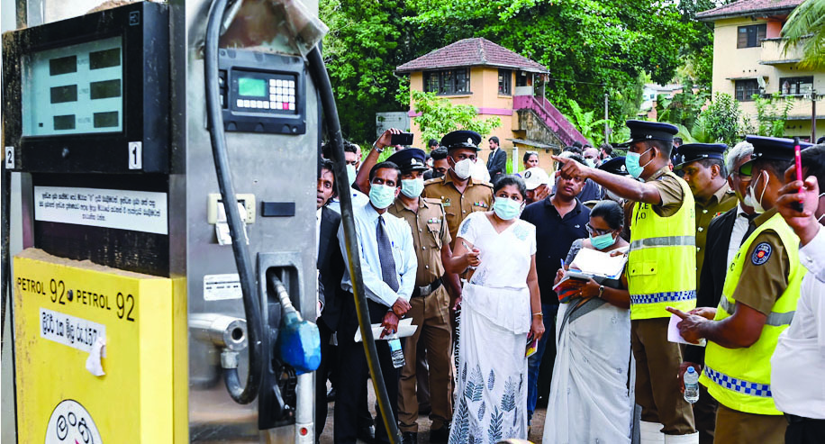 RAMBUKKANA, Sri Lanka: District magistrate Wasana Nawarathna (C) inspects a damaged Ceylon Petroleum Corporation fuel station in Rambukkana on April 20, 2022. Dried streaks of blood and spent cartridges mark the ground where a sudden crackdown by Sri Lankan police ended with the first fatality from weeks of anti-government rallies. -- AFP
