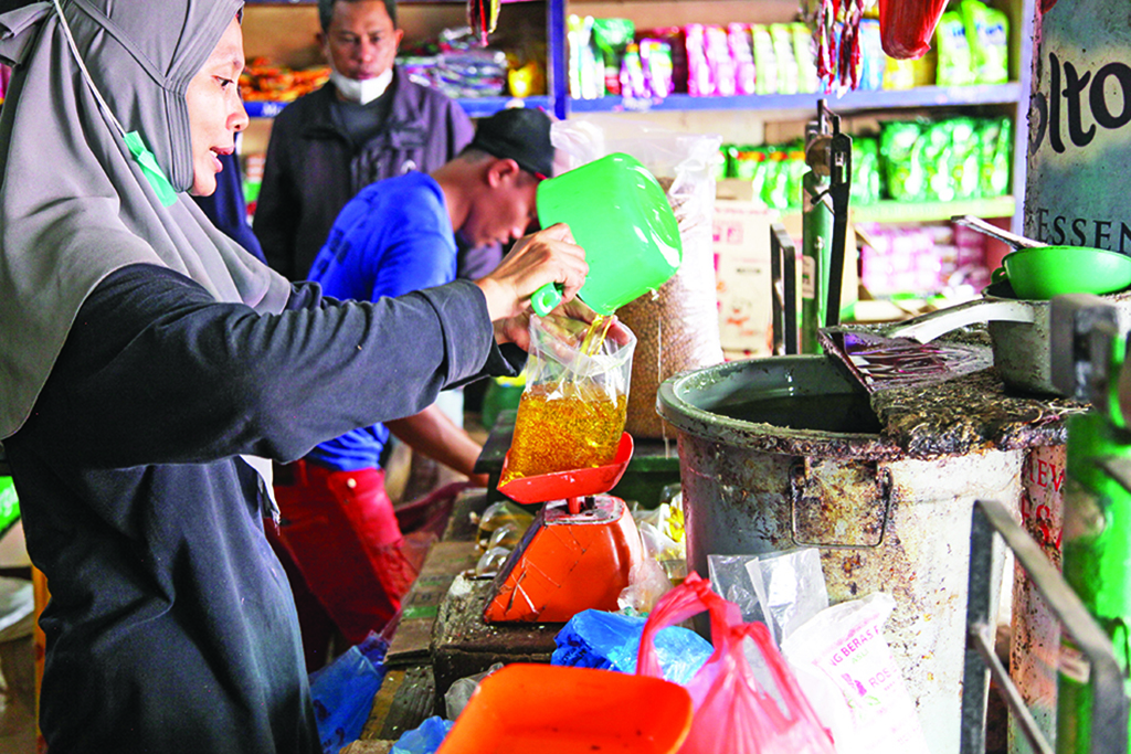 MEDAN: A vendor packs vegetable oil at a traditional market in Medan.—AFP