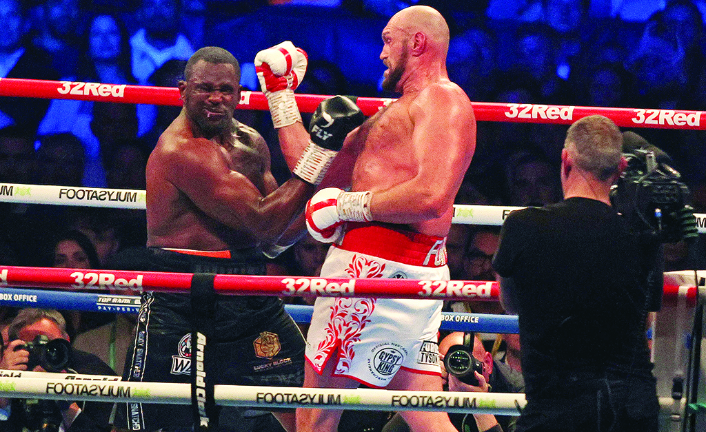 LONDON: Britain's Tyson Fury lands a punch to knock out Britain's Dillian Whyte in the sixth round and win their WBC heavyweight title fight at Wembley Stadium on April 23, 2022. - AFP