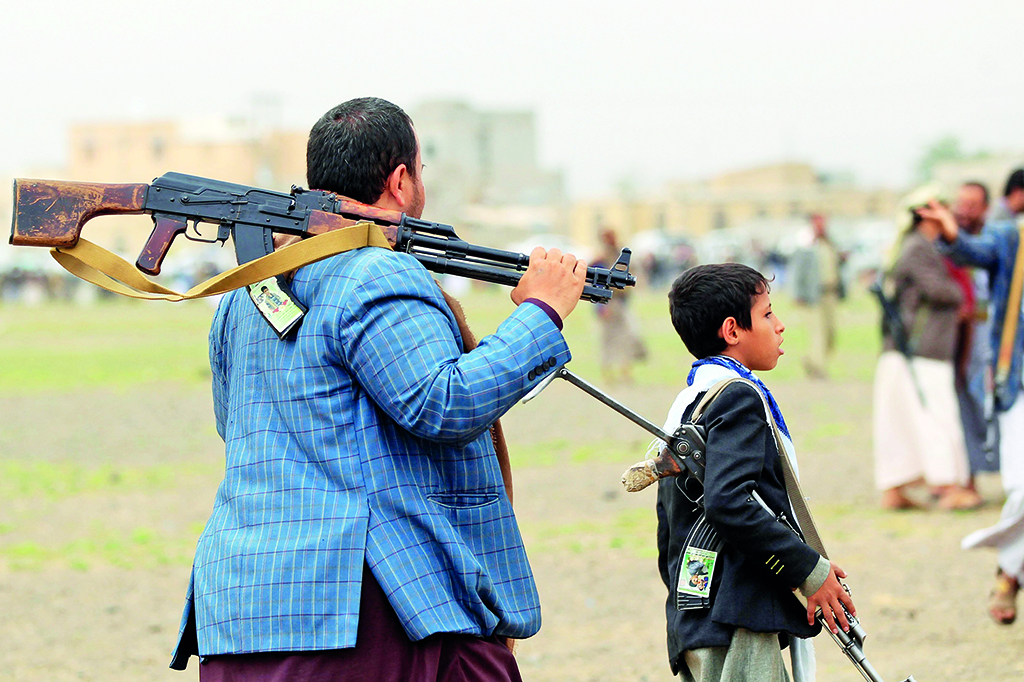 AR RAHABAH, Yemen: A young boy carrying a gun is followed by a gunman loyal to the Yemeni Houthi movement during a gathering by tribesmen to show support to the Shiite fighters against the Saudi-led intervention, in the Rahabah district.- AFP