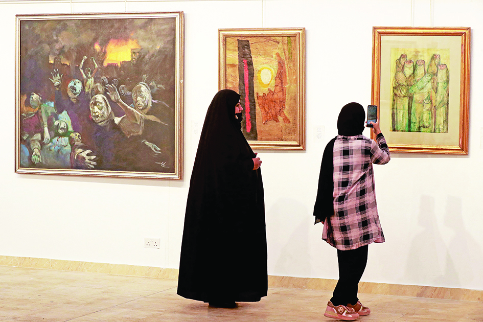 Visitors look at paintings by renowned artist Fayiq Hassan on display at Iraq's Ministry of Culture in Baghdad.—AFP photos